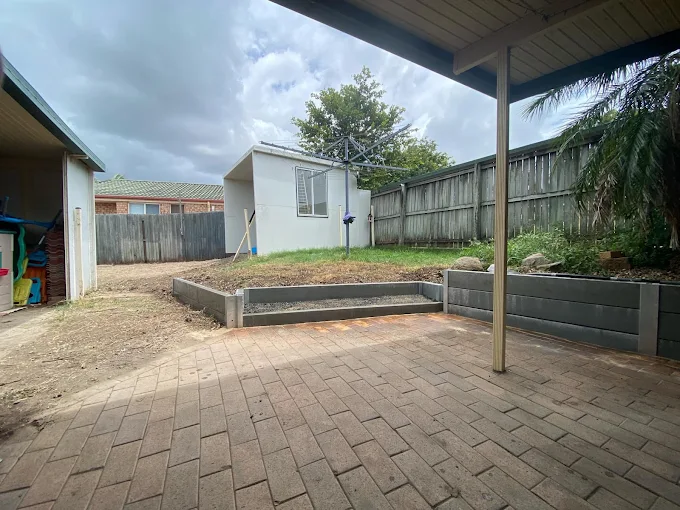 New dark retaining wall and steps in a backyard